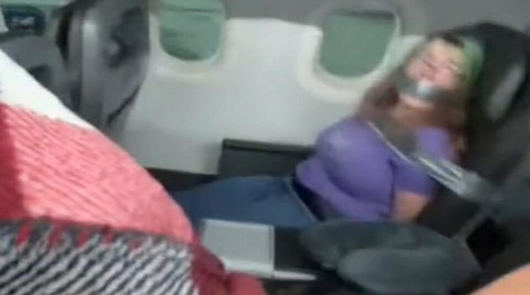 video mulher paga de doida e amarrada e amordacada durante voo da american airlines